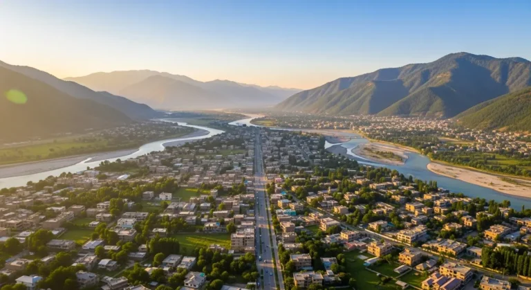 Aerial sunrise panorama of Swat Valley housing schemes near Mingora, Saidu Sharif, and Kanju Township with river and mountains